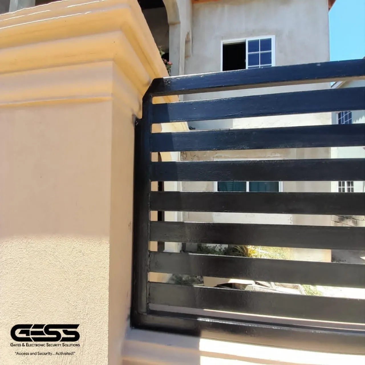 Black horizontal slat fence panel returning off a rendered pillar