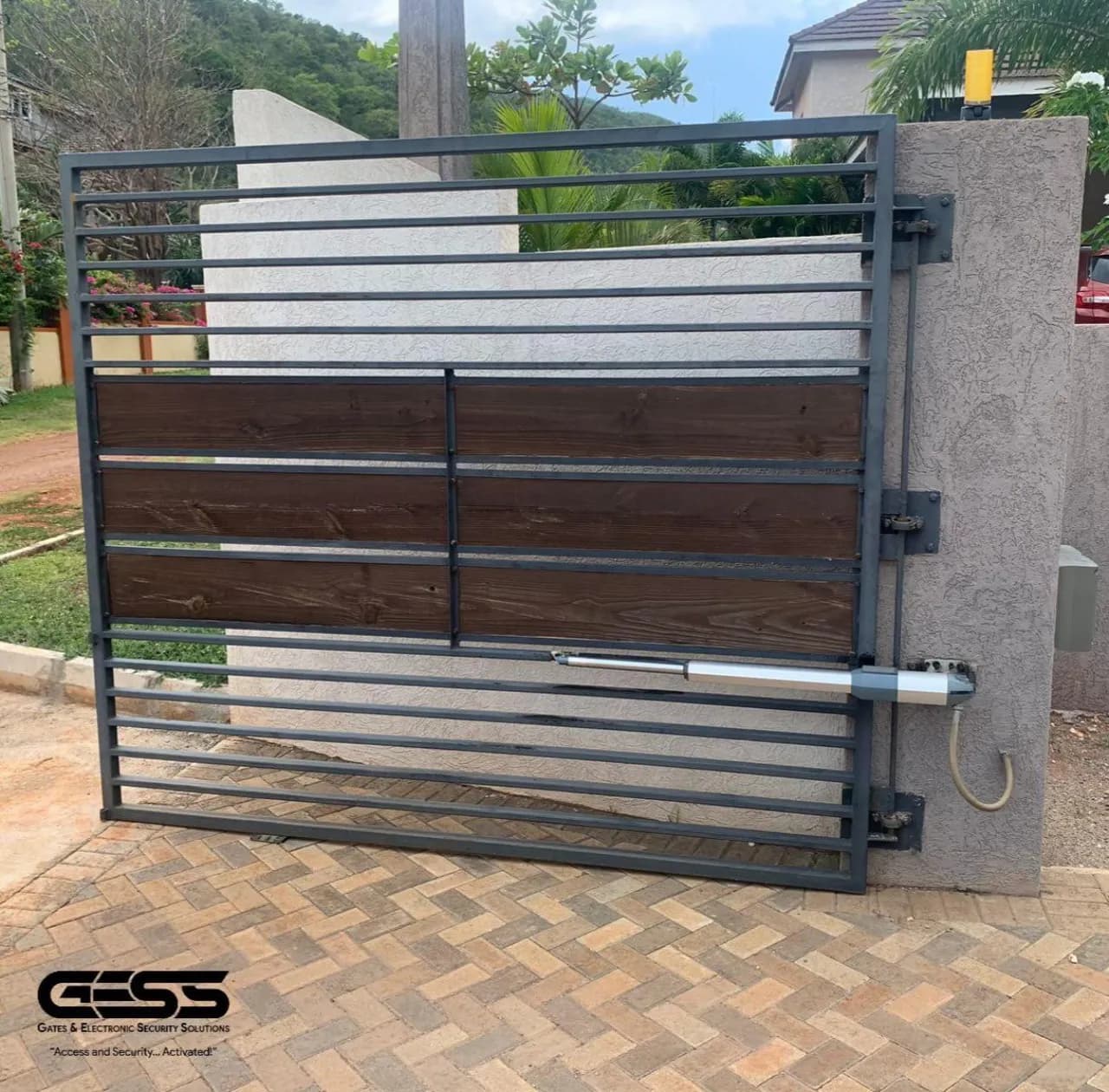 Timber-and-steel swing gate with a linear arm operator on the pillar